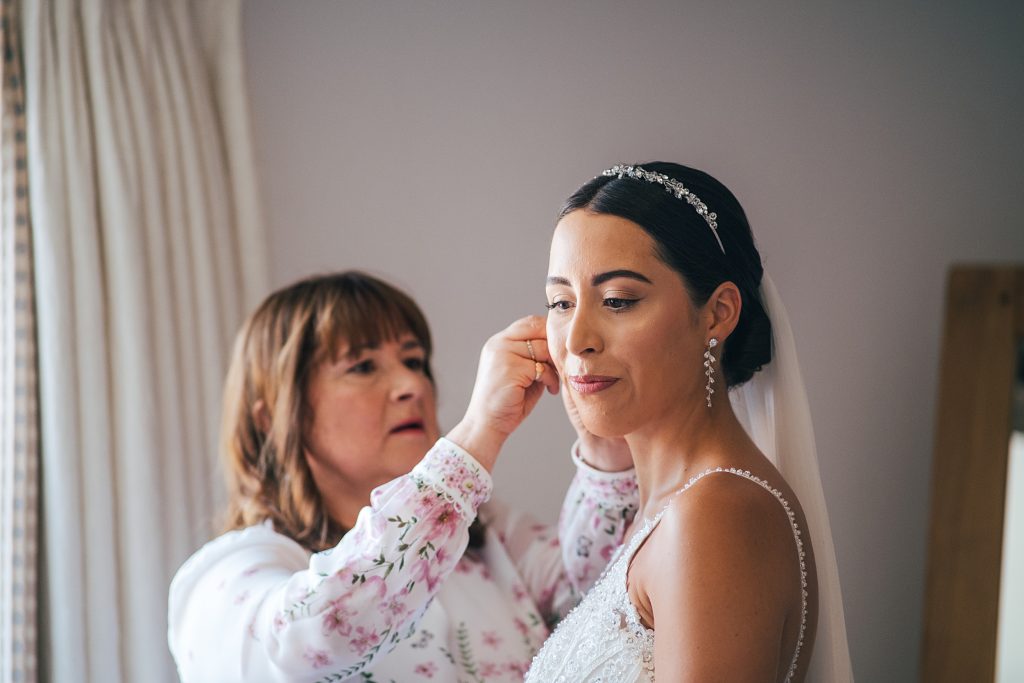 Mum puts in daughters earrings on wedding morning