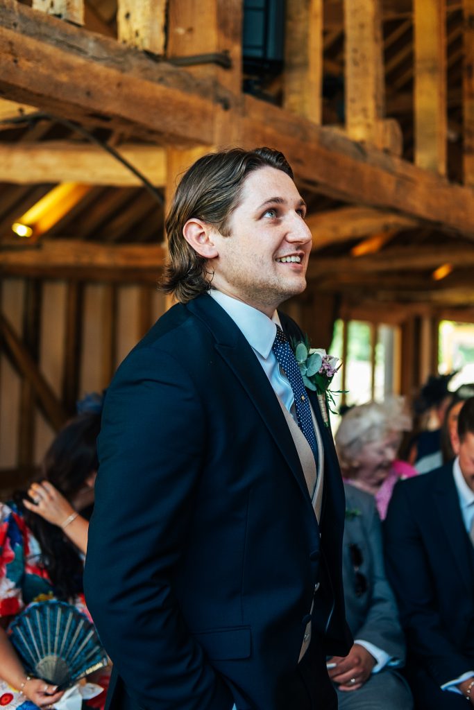 groom looks nervous as he waits for bride