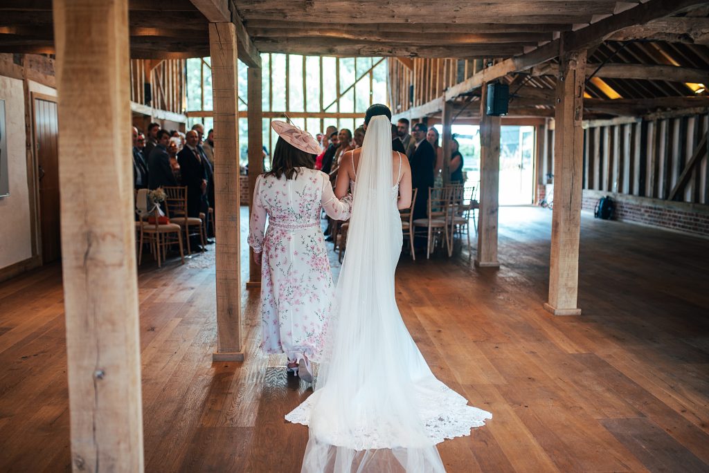 rear view of bride and mum walking down aisle