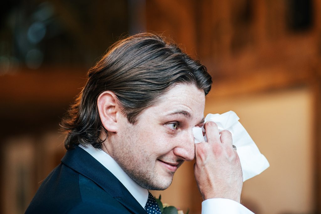 groom wipes away a tear