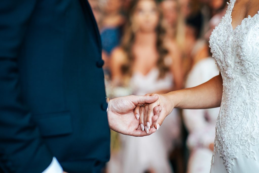 close up of bride and groom holding hands