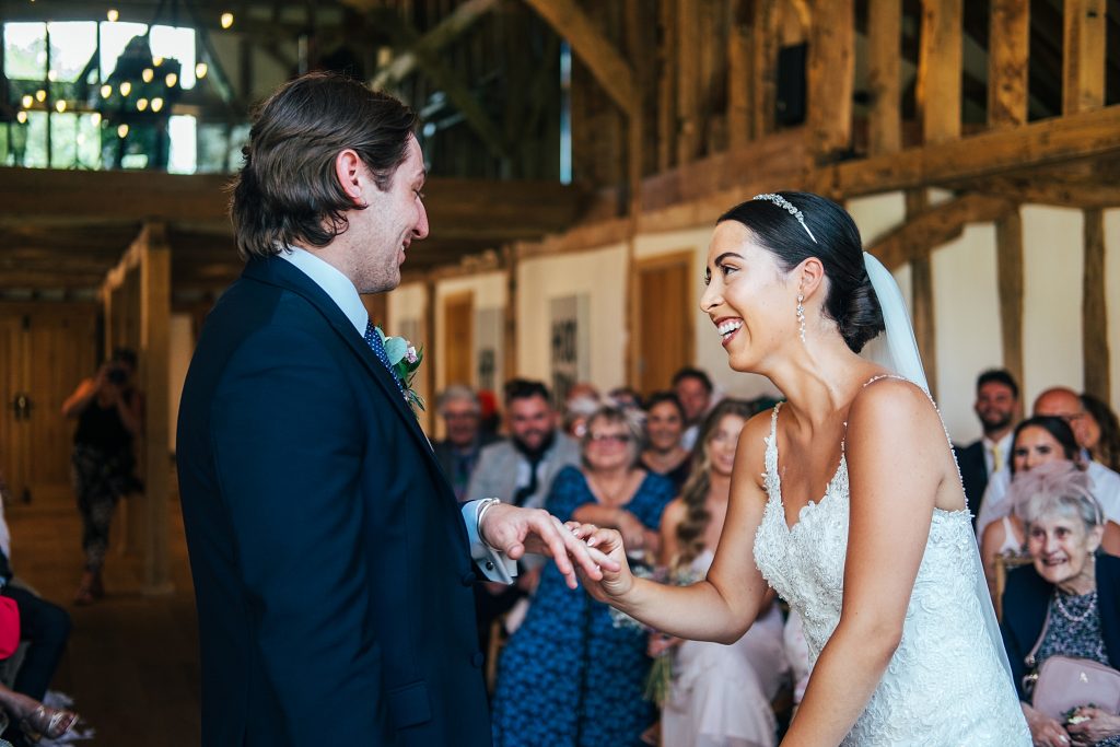 bride and groom laugh as they exchange rings