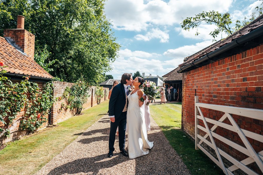 bride and groom kiss in gateway