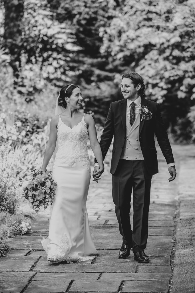 bride and groom stroll in gardens