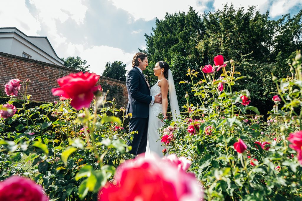 bride and groom in pink rose garden