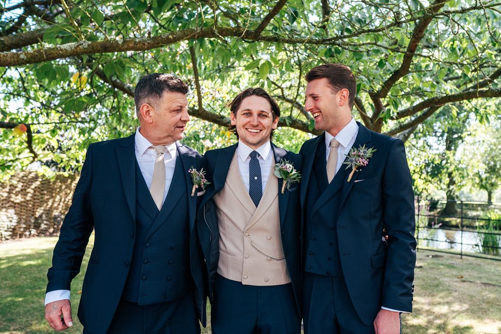 groom with groomsmen under a tree