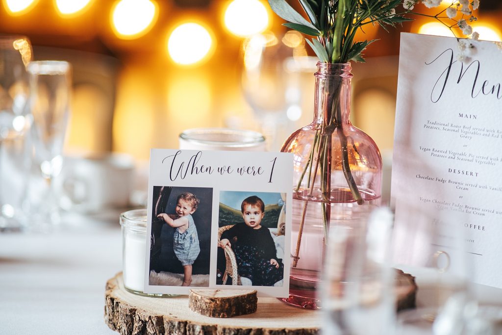 table number place card with photos of bride and groom when they were babies