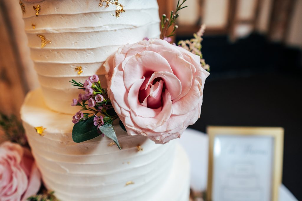 close up of pink flowers on wedding cake
