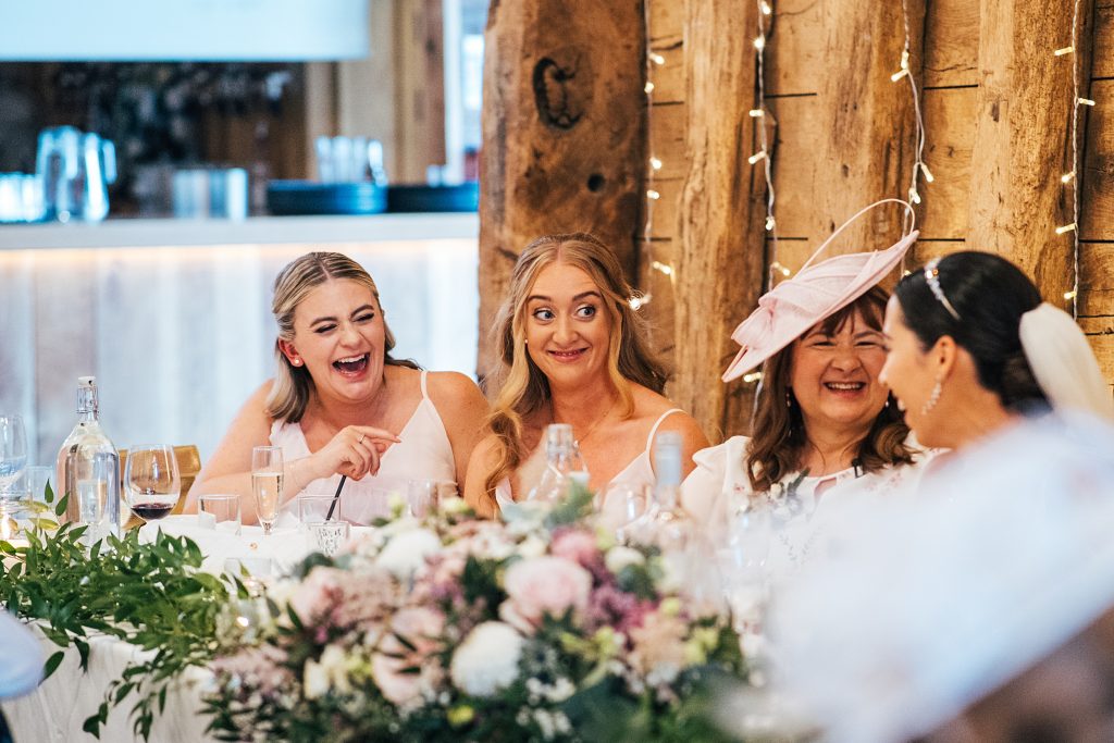 bridesmaids laugh and pull faces at speeches