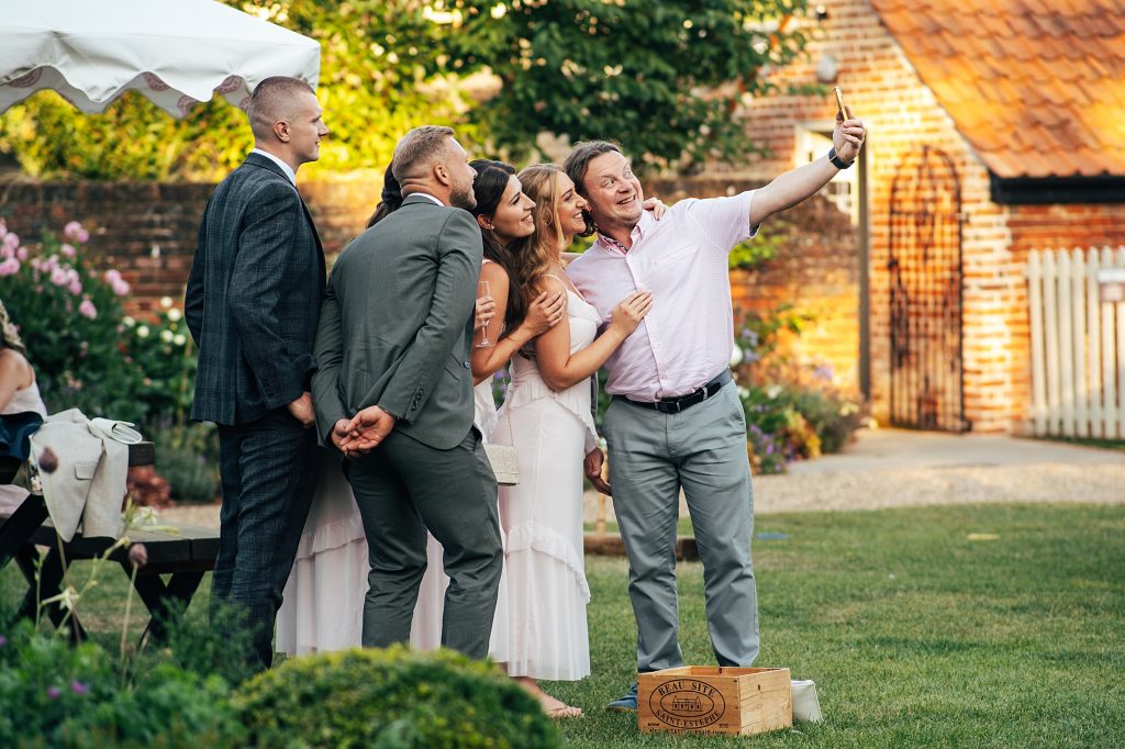 guests take a group selfie on lawn