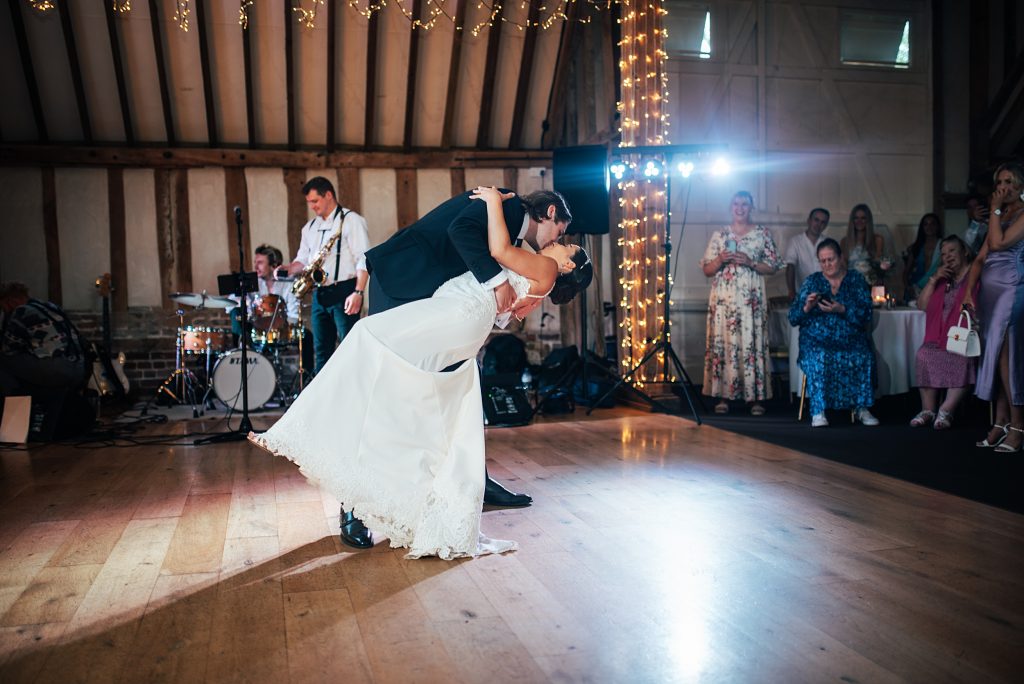 groom dips and kisses bride on dance floor