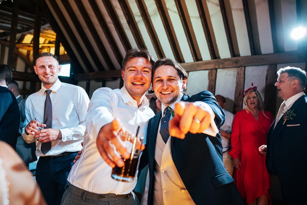 guests laugh and point to camera on dance floor