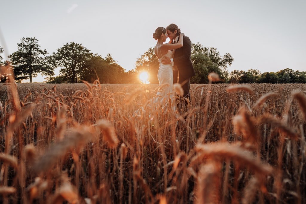 bride and groom in wheatfield at sunset