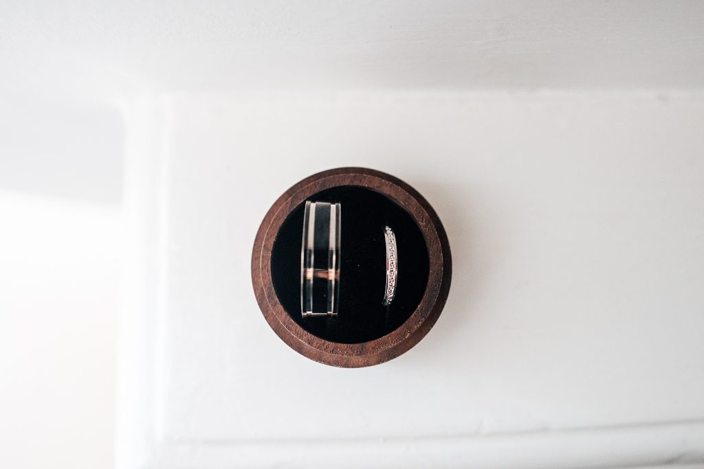 view of wedding rings in brown wooden box from above