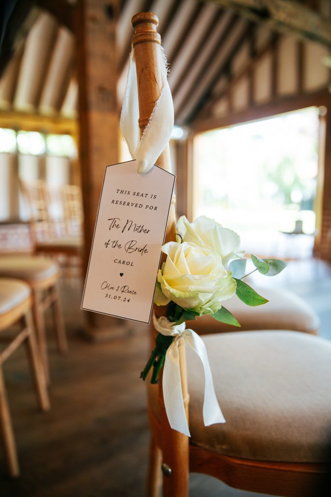 name tag and white rose on chair