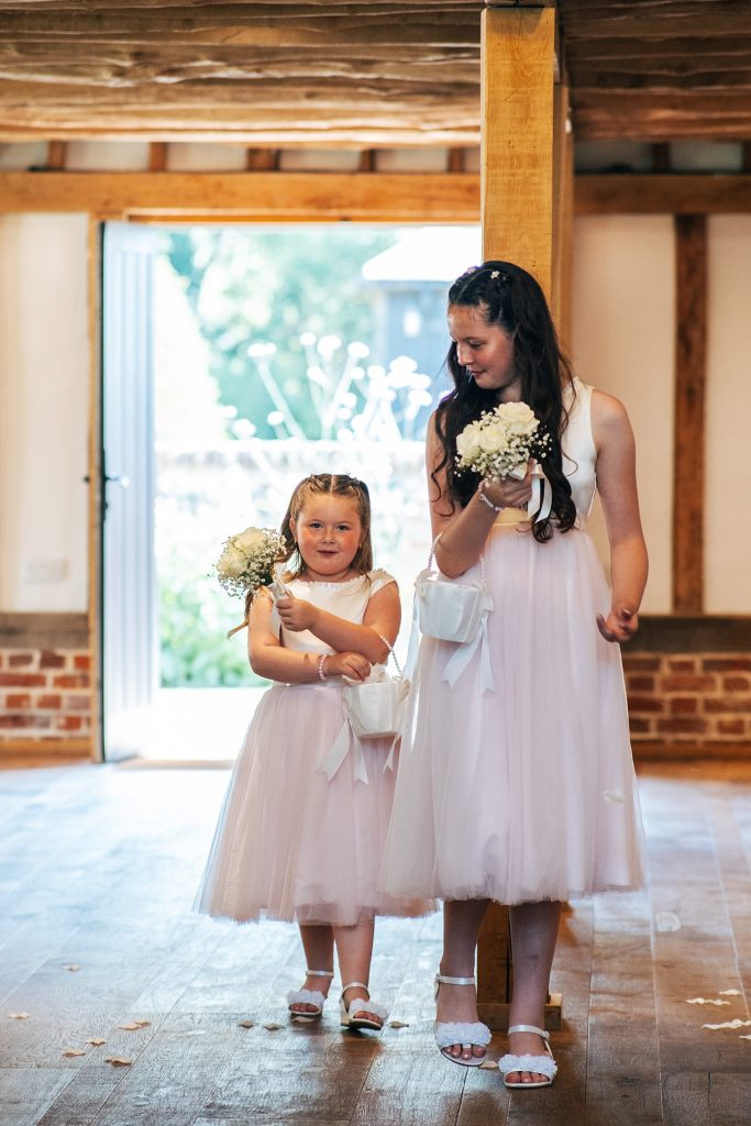 flower girls walk down aisle and spread flower petals