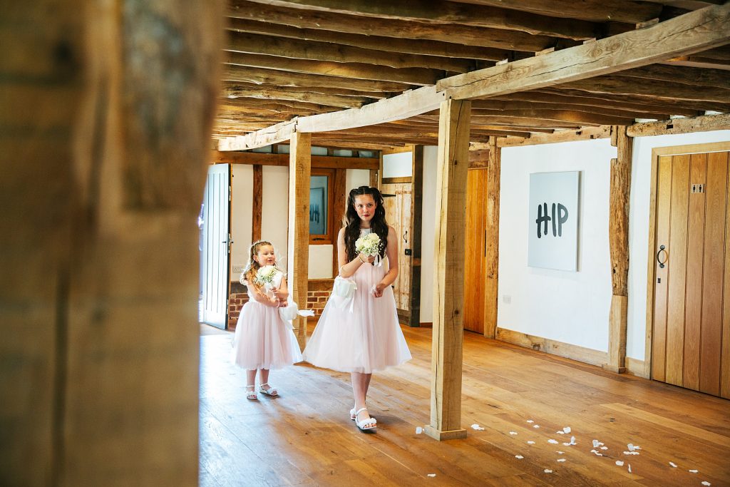 flower girls throw petals as they walk down aisle