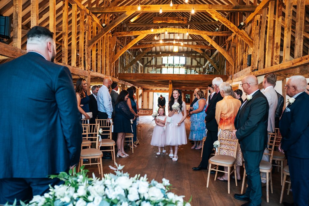 flower girls throw petals as they walk down aisle
