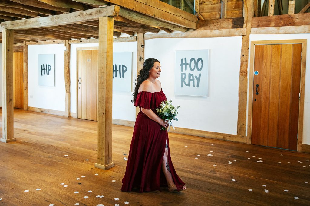 bridesmaid in red walks down aisle
