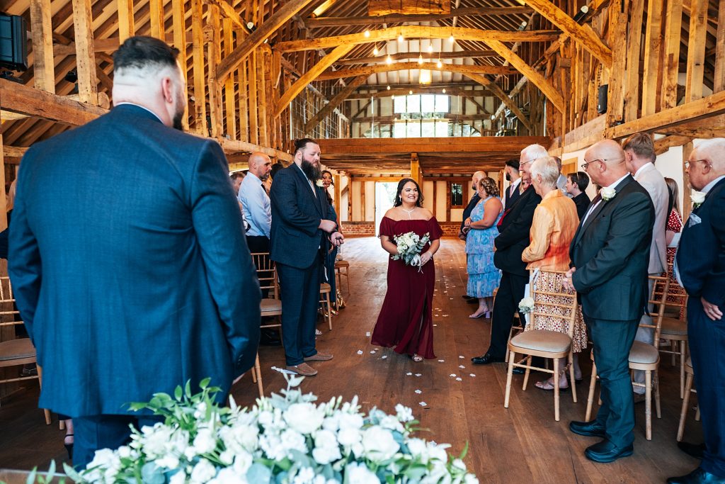 bridesmaid in red walks down aisle