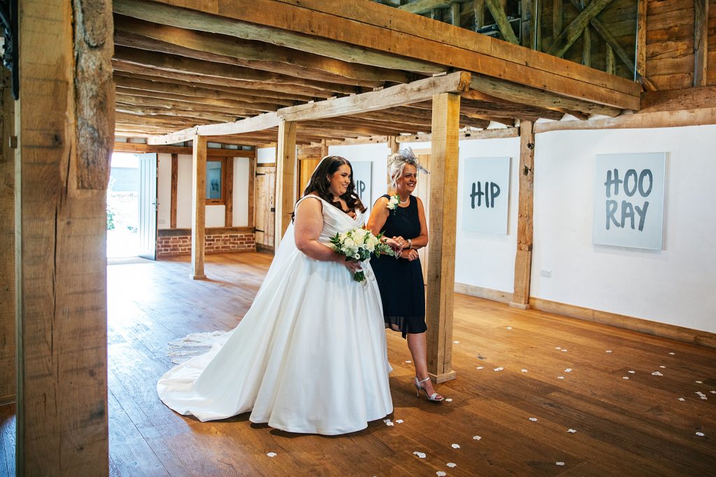 bride walks down aisle with her mum