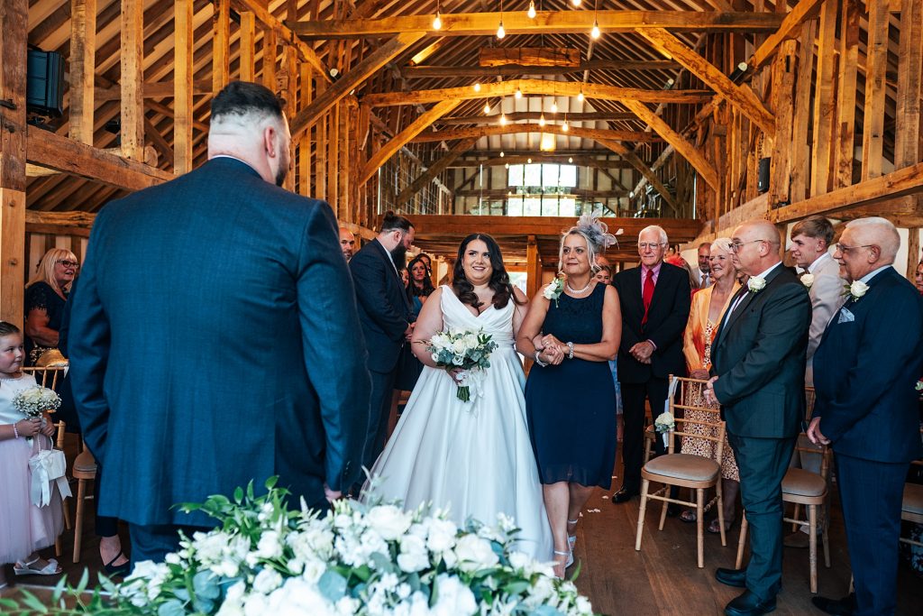 bride walks down aisle with her mum