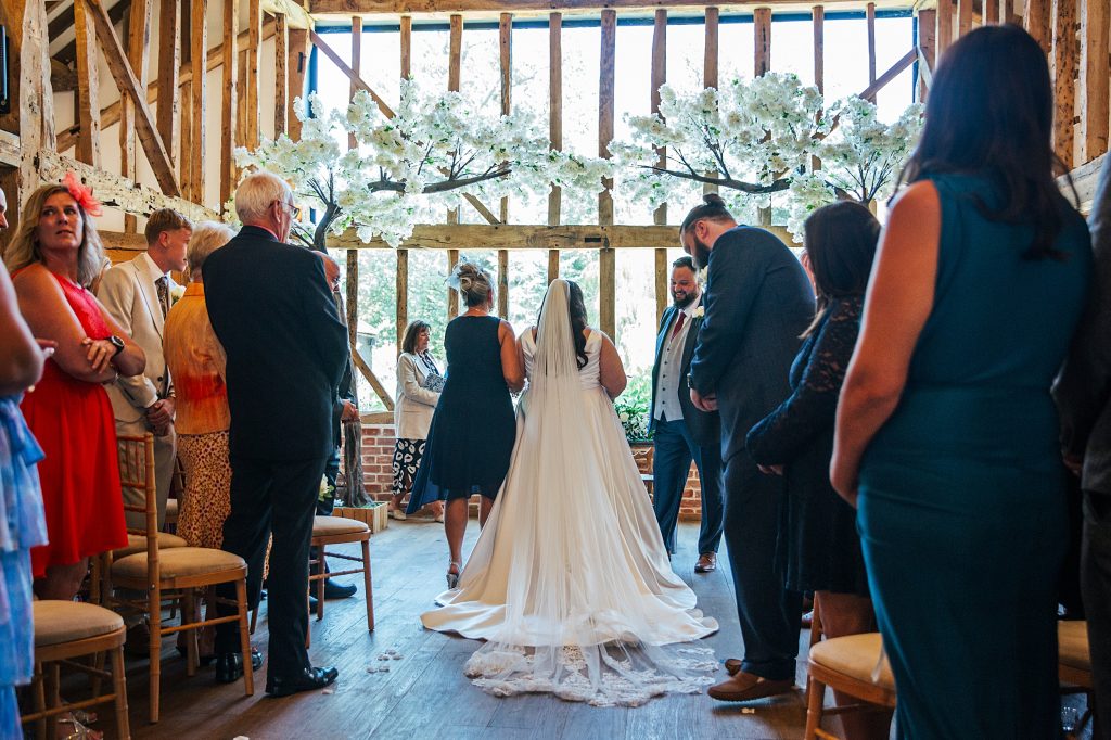 back view of bride meeting groom at top of aisle