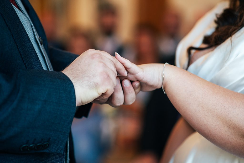 groom puts ring on bride