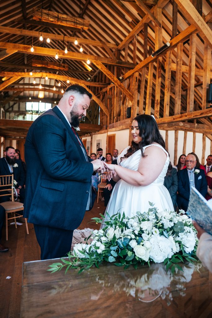 groom puts ring on bride