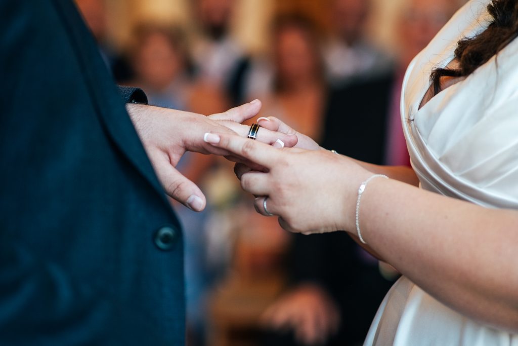 bride puts ring on grooms finger