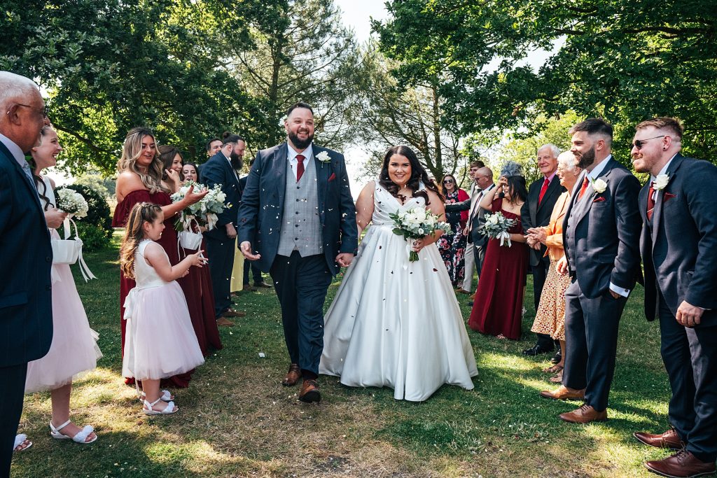 bride and groom walk confetti tunnel