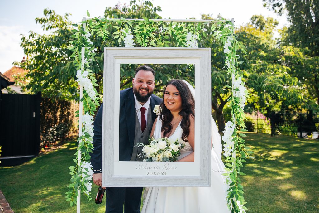 bride and groom pose in a frame