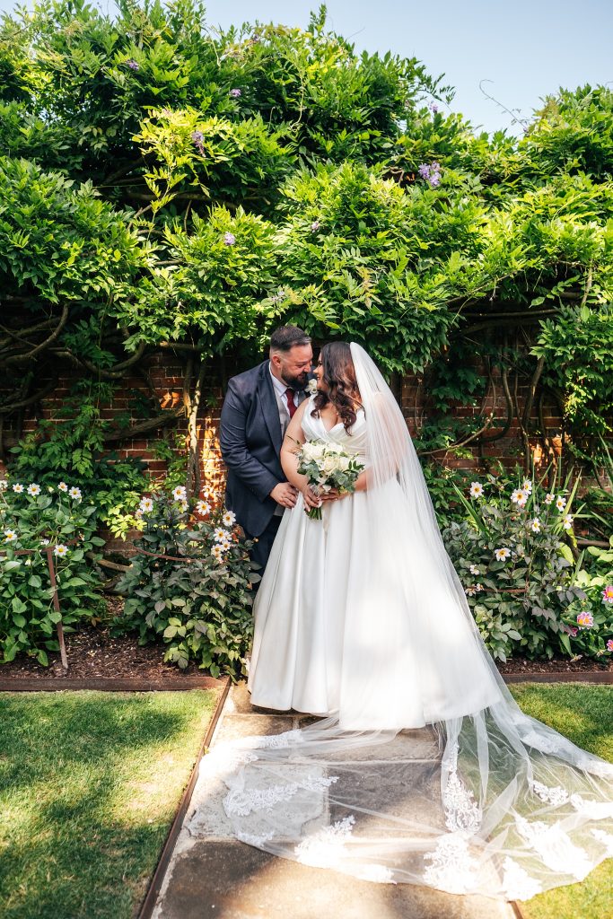 bride and groom in gardens at Blake Hall