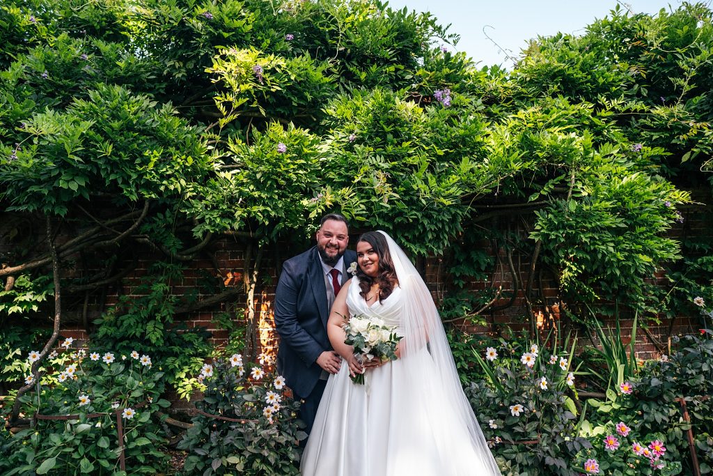 Bride and groom in walled gardens at Blake Hall