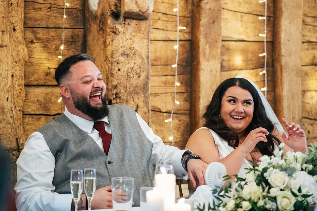 bride and groom laugh at speech