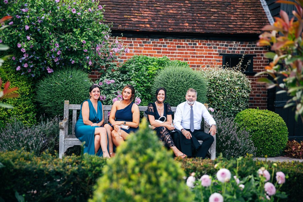 guests on a bench in a garden at sunset