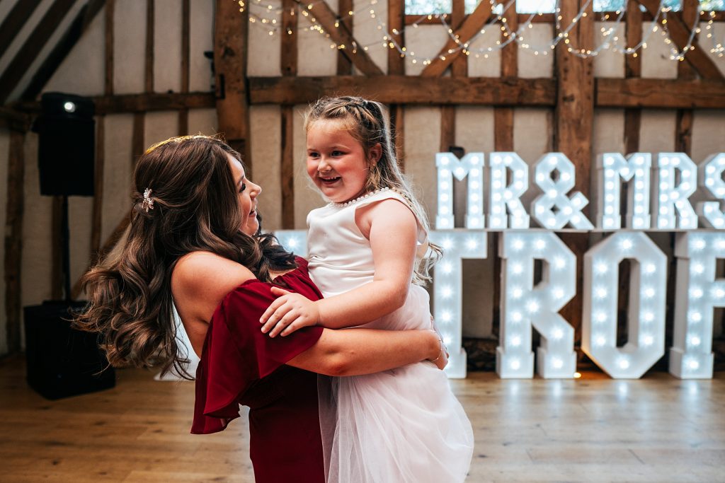 bridesmaid swings flower girl on dance floor