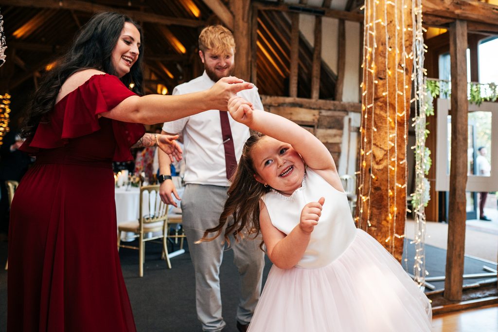 bridesmaid spins flower girl on dance floor