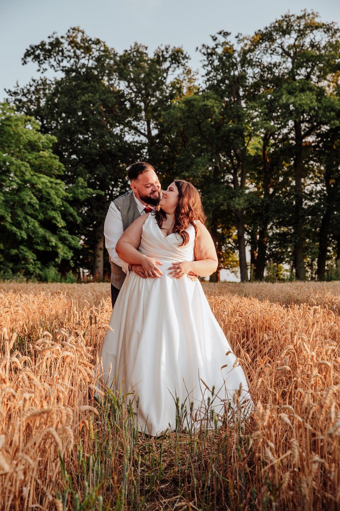 bride and groom in wheat field at sunset