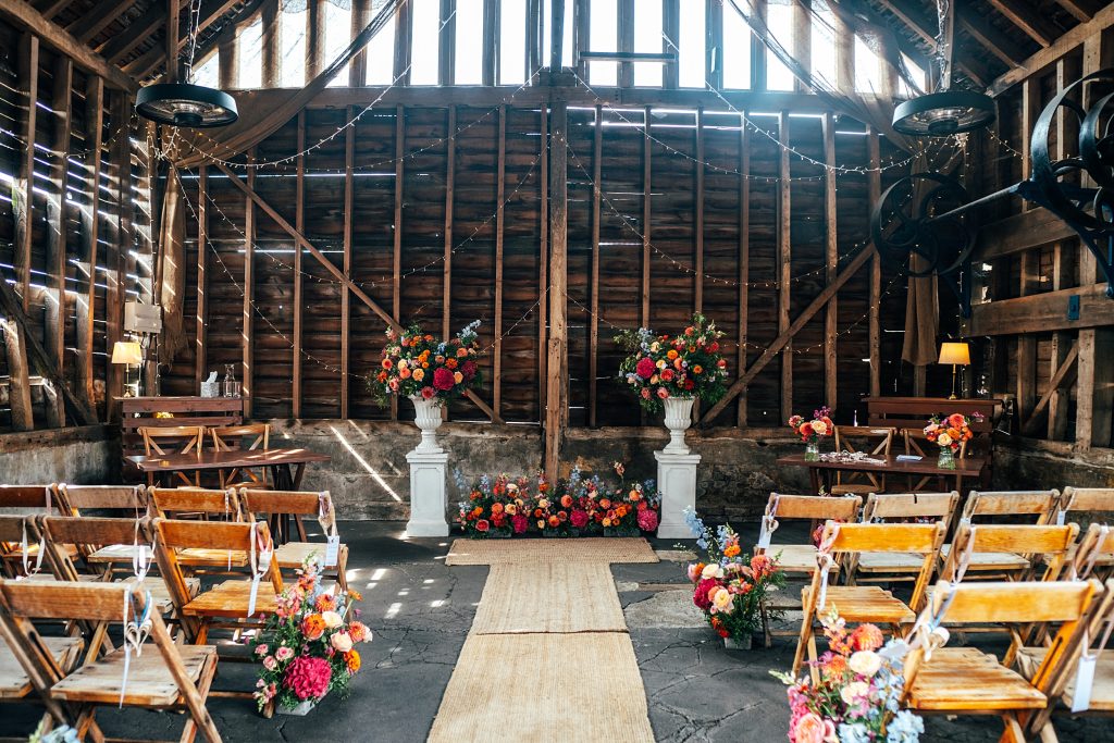 Rustic barn decorated with pink and orange blooms