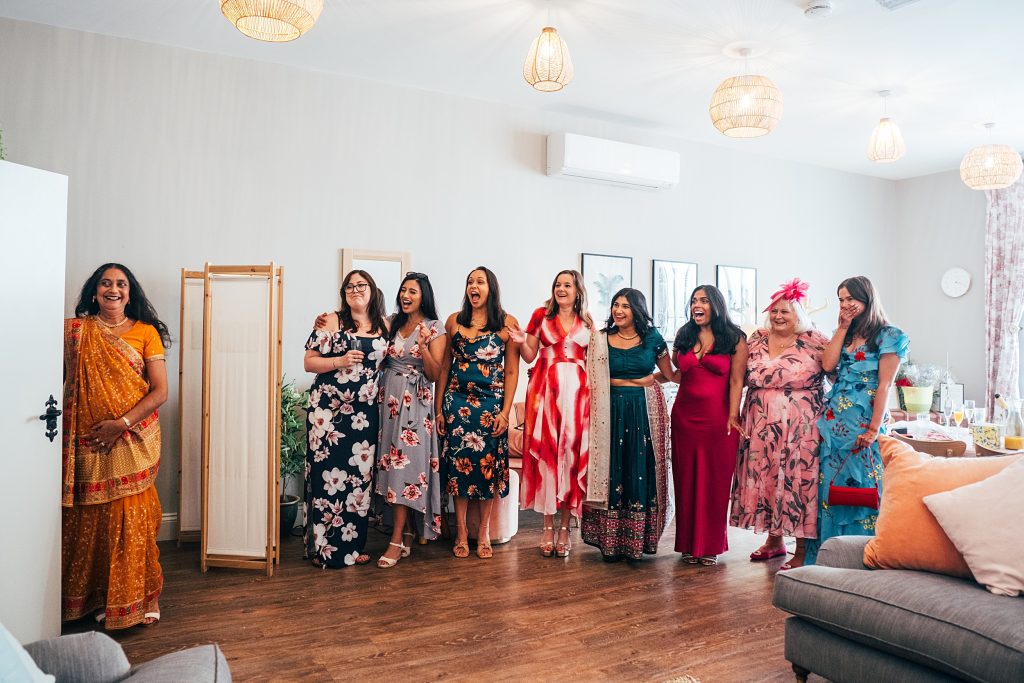 brides mum and her friends welcome her as she enters bridal prep room