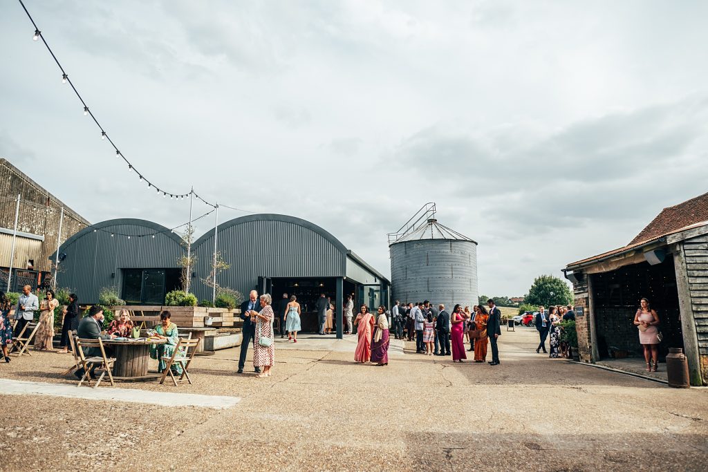guests mingle in courtyard pre ceremony at The Barns at Lodge Farm