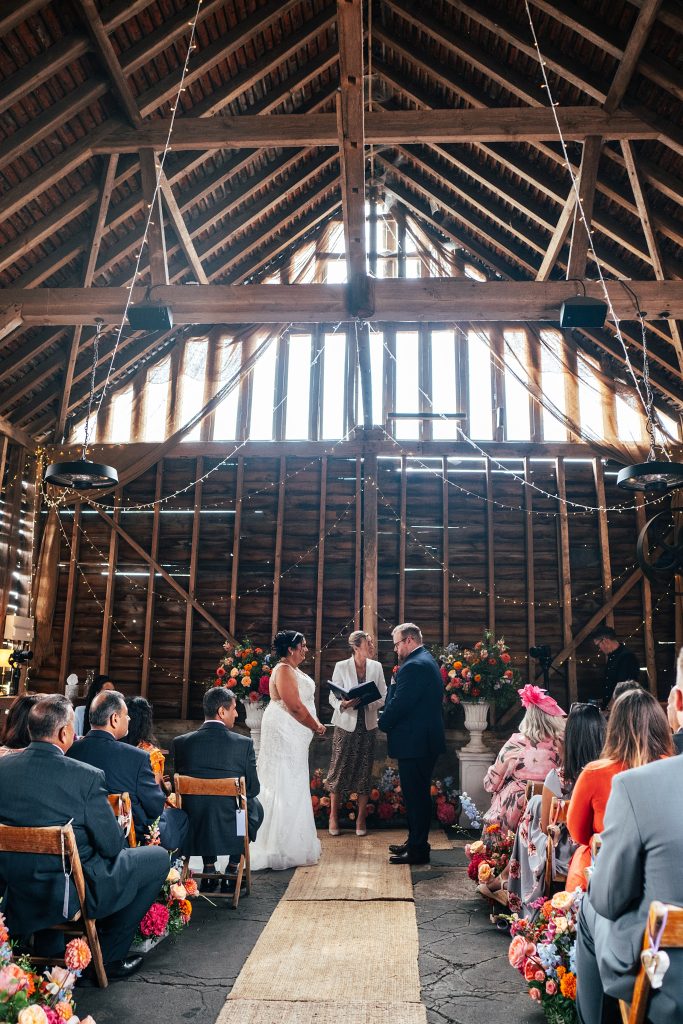 view from behind of wedding ceremony in rustic barn