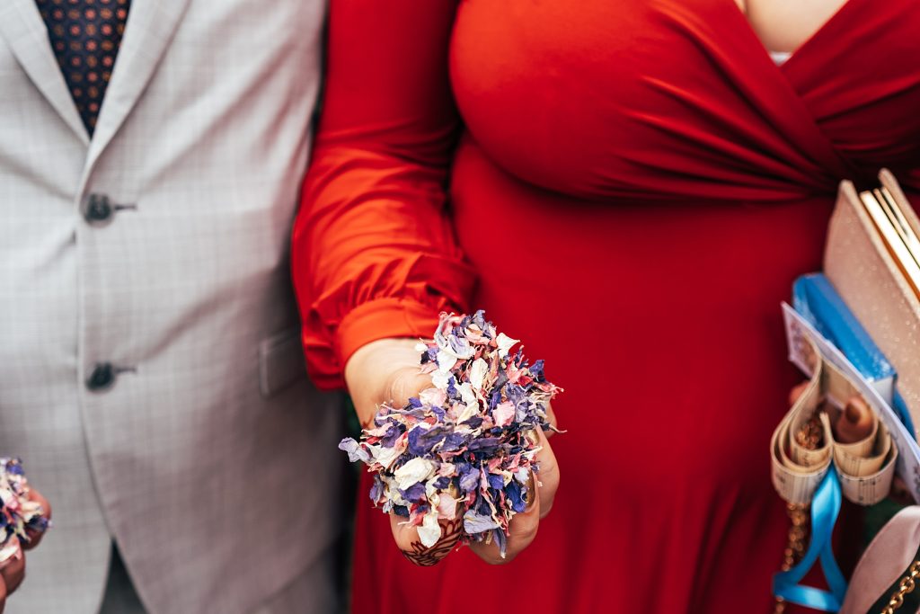 close up of guest with a handful of petal confetti