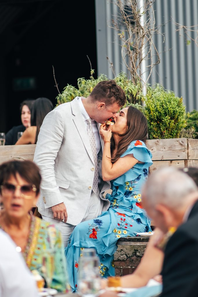 wedding guest couple share a bit of cake