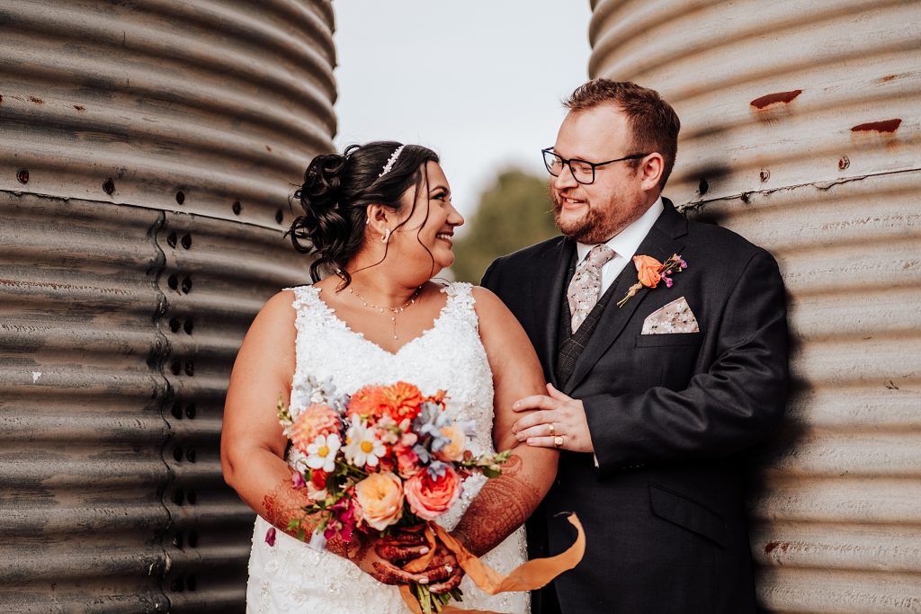 bride and groom in between two grain silos