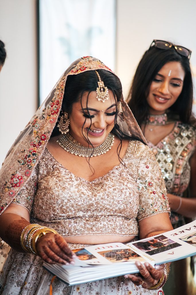 smiling bride looks through photo book gift
