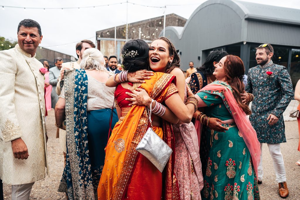 Grooms sister hugs brides mum during Jaan