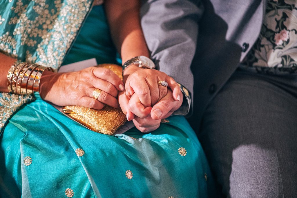close up of wedding guests holding hands