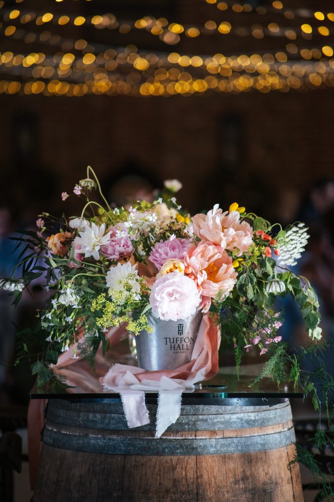 Pastel big blousy bouquet in wine bucket at Tuffon Hall Essex documentary wedding photographer